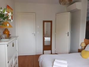a white bedroom with a bed and a mirror at Villa Do Sol Chambre d'Hôtes "Arbousiers" in Arcachon