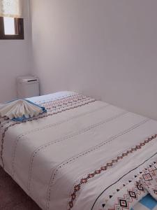 a bed with a white blanket on top of it at Habitación Ático Sol y Mar in Rincón de la Victoria