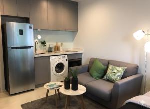 a living room with a couch and a kitchen at Thong Lor condo Next to BTS in Bangkok
