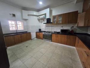 a large kitchen with wooden cabinets and a stove at The Nest in Aso +4 photos