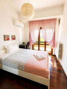 a bedroom with a bed and a large window at B&B Colombo in Pisa