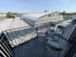 a balcony with chairs and a table and a building at LuxApart2Cologne in Kerpen
