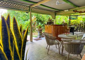 a patio with chairs and a table and some plants at Buisson Guesthouse in La Digue