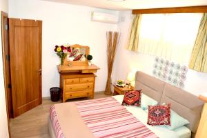 a bedroom with a bed and a dresser and a mirror at Central villa flatlet with pool - free parking and WiFi in Lija +41 photos