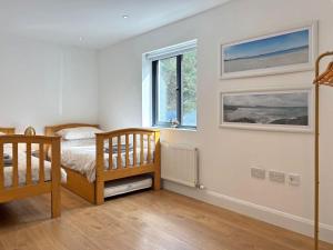 a bedroom with a bed and two windows at Cottage 503 - Leenane in Leenaun