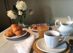 a table with plates of food and a cup of coffee at B&B Il Girasole in Cuneo
