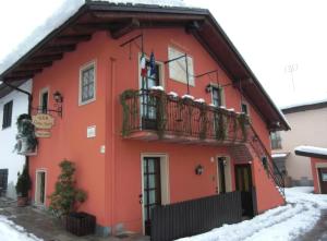a red house with a balcony in the snow at B&B Il Girasole in Cuneo