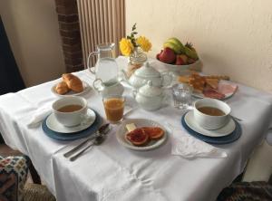 a table with cups and saucers of coffee and food at B&B Il Girasole in Cuneo +18 photos