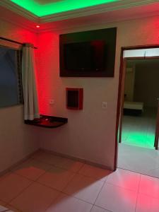 a room with red and green lights on a wall at Hotel tenda 2 in Guarulhos