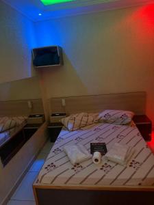 a small bedroom with a bed and a tv at Hotel tenda 2 in Guarulhos