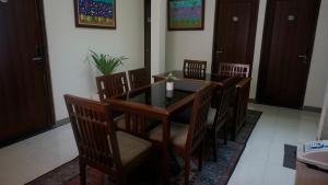 a dining room with a table and wooden chairs at The Cabin Hotel Wirobrajan in Yogyakarta