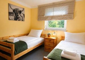 a bedroom with two beds and a picture of a bull on the wall at Großes Ferienhaus Bucheneck für Gruppen, Familien & Firmen 7 Schlafzimmer 3 Bäder große Terrasse nahe Rhododendronpark Kromlau in Kromlau