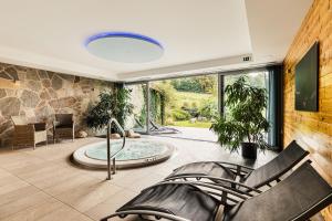a living room with a large window and a hot tub at Statek Samsara in Blansko