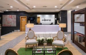 a lobby with two chairs and a reception desk at Hesperia A Coruña Centro in A Coruña