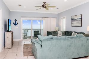 a living room with a couch and a ceiling fan at Five on the Beach by Pristine Property Vacation Rentals in Cape San Blas