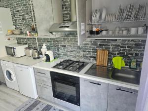 a kitchen with a stove and a washer and dryer at Eolie House - Sea View in Tropea