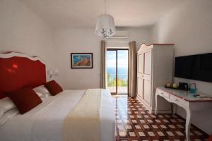 a bedroom with a bed and a desk and a television at Il Canneto in Positano