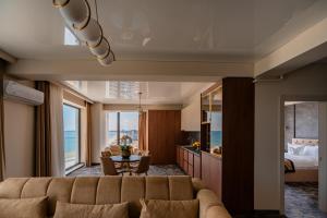 a living room with a couch and a bedroom at Noble Hotel by Building Stefan in Mamaia Sat/Năvodari