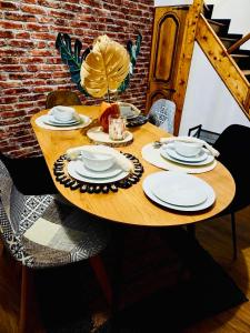 a wooden table with plates and dishes on it at Bohéme Chic in Saint-Dizier