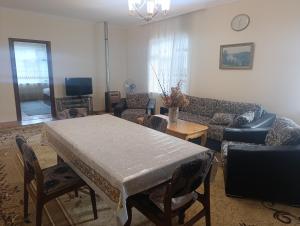 a living room with a table and a couch at Zaqatala-Car riverside cottage in Zaqatala