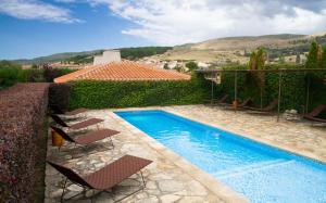 a swimming pool with chairs and a house at Belle Torre Mayorazgo Boutique Hotel in Villatoro +16 photos