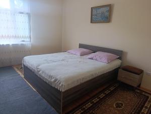 a bedroom with a bed with two pink pillows at Zaqatala-Car riverside cottage in Zaqatala