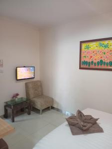 a room with a bed and a chair and a table at The Cabin Hotel Wirobrajan in Yogyakarta