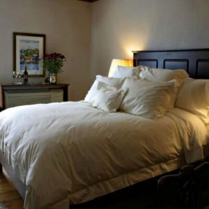 a bedroom with a bed with white sheets and pillows at Mariner King Inn in Lunenburg