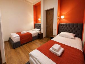 a hotel room with two beds and orange walls at BB Old City in Tbilisi City