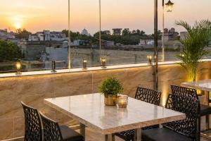 a table and chairs on a balcony with a view at Hotel Wilkisto By Amar Singh Near Taj Mahal in Agra