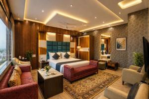 a hotel room with a bed and a couch at Hotel Wilkisto By Amar Singh Near Taj Mahal in Agra