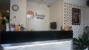 a counter in a restaurant with a clock on the wall at The Cabin Hotel Wirobrajan in Yogyakarta