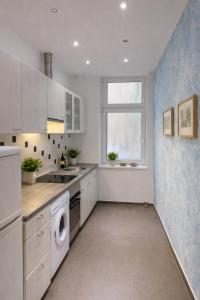 a kitchen with white cabinets and a washer and dryer at Gelsenkirchen Am Flöz in Gelsenkirchen