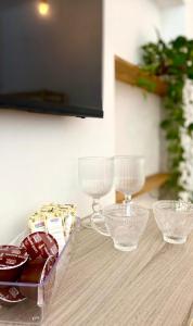 a table topped with glass bowls and wine glasses at Casa Freitas - Suíte 2 in Extrema