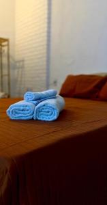 three blue towels sitting on top of a bed at Casa Freitas - Suíte 2 in Extrema