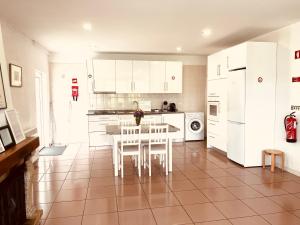 a kitchen with white cabinets and a table and chairs at Casa de Casarelhos - "Gerês" in Geres
