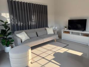 a living room with a couch and a tv at Tiny Home - Hin Lad Waterfall in Nathon Bay