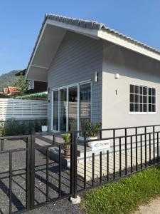 a house with a fence in front of it at Tiny Home - Hin Lad Waterfall in Nathon Bay