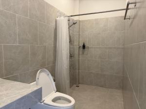 a bathroom with a shower with a toilet and a shower curtain at Tiny Home - Hin Lad Waterfall in Nathon Bay +3 photos