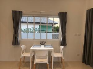a dining room with a table and chairs and a window at Tiny Home - Hin Lad Waterfall in Nathon Bay