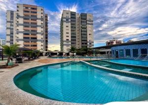 a large blue swimming pool with two tall buildings at Apto Aquarius - Piscinas Aquecidas, Hidro e Lazer Total - até 5 Pessoas in Caldas Novas