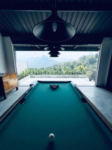 a pool table in a room with a large window at ARHH castle in Ginigathena