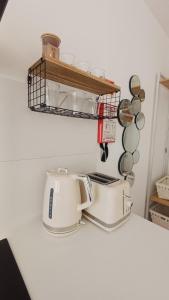 a toaster on a counter with a shelf and pans at Seabird Lisbon Studio in Charneca