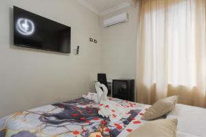 a bedroom with a bed with a tv on the wall at Rosa Italia Hotel Roma in Rome