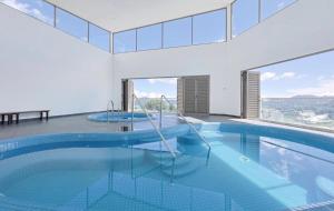 a swimming pool with blue water in a building at Sungai palas Horizon in Cameron Highlands