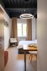 a bedroom with a bed and a table and a window at Skala Hostel in Almaty