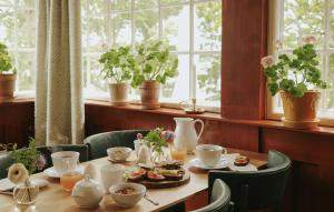 a table in a room with plants on a window at Badhotellet Villa Berg in Norrtälje