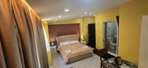a small bedroom with a bed and a bathroom at CityCenterHotel Shkoder in Shkodër +70 photos