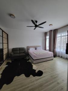 a bedroom with a bed and a ceiling fan at Puteri Elaisha Homestay in Batu Arang