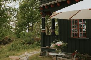 a black house with a table and a window at Badhotellet Villa Berg in Norrtälje
